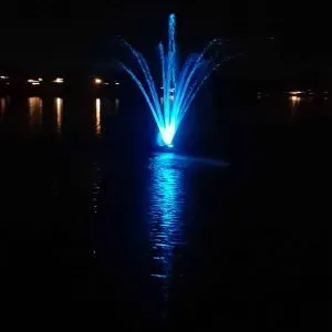 Blue-lit water fountain at night.