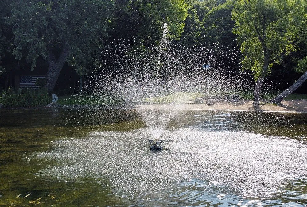 Fountain spraying water in a park pond.